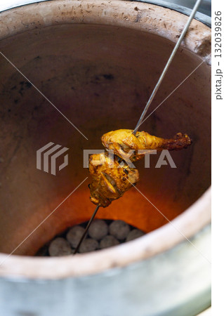 Tandoori chicken cooking in a traditional clay oven Tandoori chicken cooking in a traditional clay oven 132039826