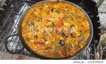 Traditional spanish paella with seafood and vegetables on outdoor grill. Typical cuisine of Spain. Valencian cuisine. Stage of cooking paella. Ingredients for paella Traditional spanish paella with seafood and vegetables on outdoor grill. Typical cuisine of Spain. Valencian cuisine. Stage of cooking paella. Ingredients for paella 132039920