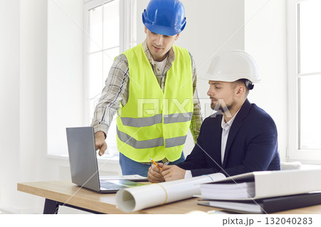 Builder Showing Construction Or Renovation Plan On Laptop To Property Owner Builder Showing Construction Or Renovation Plan On Laptop To Property Owner 132040283