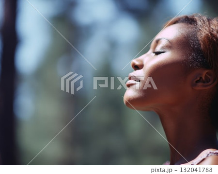 Girl enjoying deep breath in natural forest with green leaves and gentle glow. Health and tranquility shown in peaceful outdoor moment. Girl enjoying deep breath in natural forest with green leaves and gentle glow. Health and tranquility shown in peaceful outdoor moment. 132041788