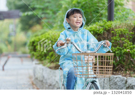 雨の日にレインコートを着て自転車に乗る子供 132041850