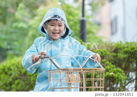 雨の日にレインコートを着て自転車に乗る子供 132041851