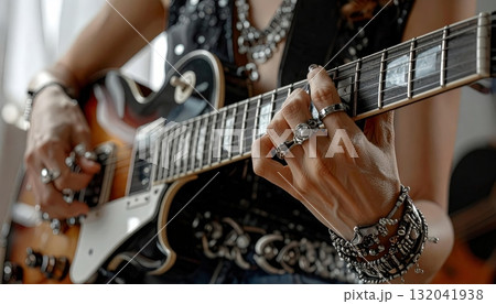 Musician's Hands Playing Electric Guitar with Ornate Jewelry and Rings Musician's Hands Playing Electric Guitar with Ornate Jewelry and Rings 132041938