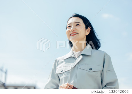 空を見上げる女性作業員 132042003