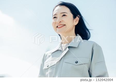 空を見上げる女性作業員 132042004