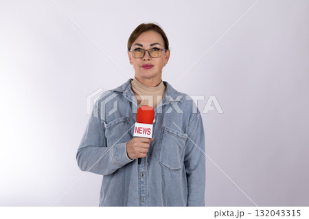 Woman in denim jacket holding a microphone on stage in front of cheering crowd Woman in denim jacket holding a microphone on stage in front of cheering crowd 132043315