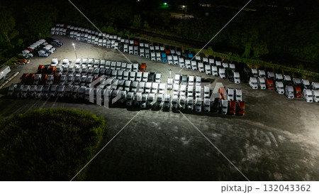 A night scene: A parking lot filled with parked cars under streetlights A night scene: A parking lot filled with parked cars under streetlights 132043362
