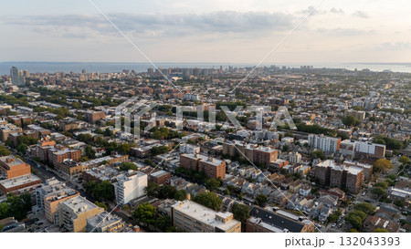 City view from hilltop: skyline with towering skyscrapers against a vivid sunse 132043393