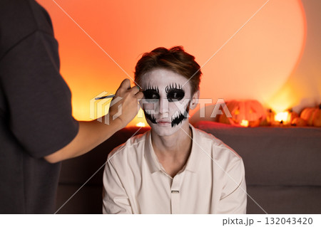 Woman displays skeleton face paint,contrasting light and hues for a Halloween Woman displays skeleton face paint,contrasting light and hues for a Halloween 132043420