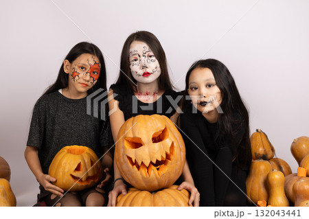 girls in Halloween masks with pumpkins, laughing and posing for the camera girls in Halloween masks with pumpkins, laughing and posing for the camera 132043441