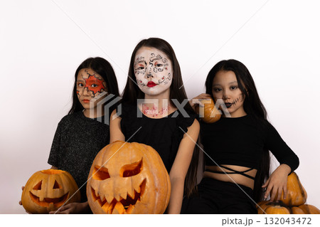 girls in Halloween costumes posing for a photo, with a spooky backdrop girls in Halloween costumes posing for a photo, with a spooky backdrop 132043472