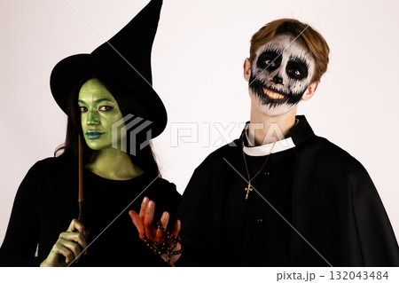 Man and woman in witch costumes surrounded by pumpkins and spider webs Man and woman in witch costumes surrounded by pumpkins and spider webs 132043484