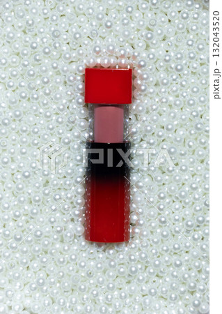 Red lipstick next to pearls, elegant and luxurious pairing 132043520