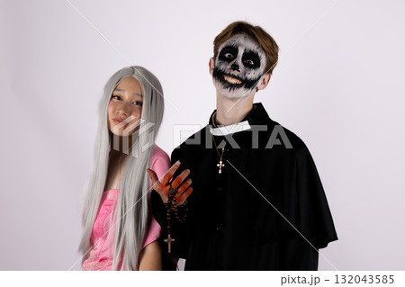 models are posing for a Halloween-themed photo, with one dressed as a skeleton 132043585
