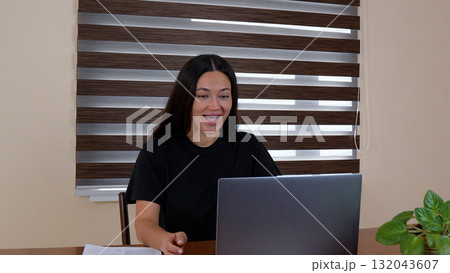 The woman is laughing while sitting at her laptop The woman is laughing while sitting at her laptop 132043607