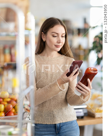 Young woman scanning qr code for ketchup 132043950