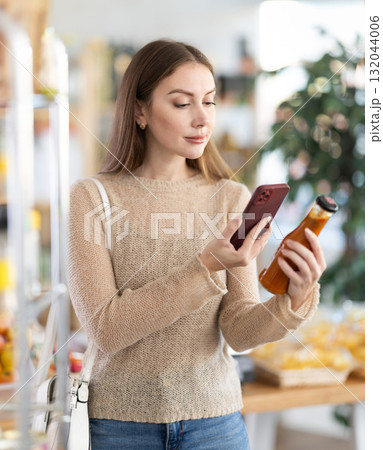 Young woman scanning qr code for chili sauce 132044006
