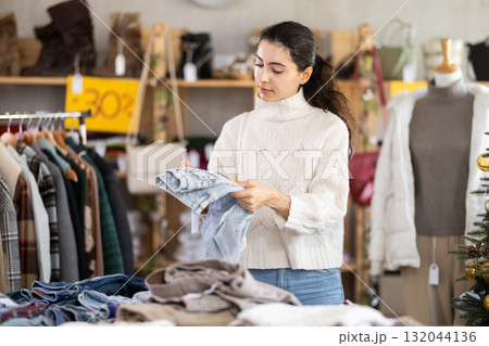 Armenian girl near showcase pick out and buying jeans, New Year eve Armenian girl near showcase pick out and buying jeans, New Year eve 132044136