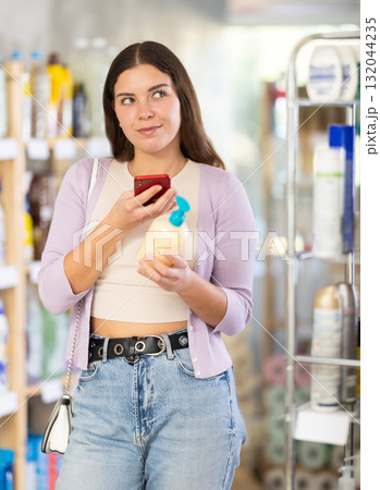 Checking expiration date of liquid hand soap - female shopper scans QR code on label of liquid hand soap using smartphone Checking expiration date of liquid hand soap - female shopper scans QR code on label of liquid hand soap using smartphone 132044235