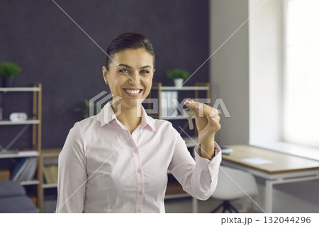 Portrait of happy smiling real estate agent holding keys to new house or apartment Portrait of happy smiling real estate agent holding keys to new house or apartment 132044296