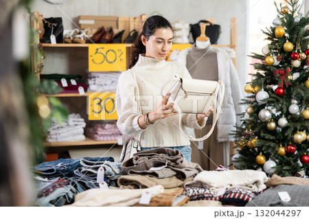 Armenian girl near showcase pick out and buying handbag, New Year eve Armenian girl near showcase pick out and buying handbag, New Year eve 132044297