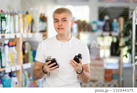 Male shopper choosing scented cosmetics in supermarket Male shopper choosing scented cosmetics in supermarket 132044375