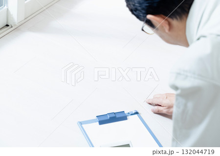 床のチェックをする作業服の男性 132044719