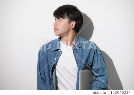 デニムでパソコンを持つ若い男性 エンジニアやデザイナー、フリーランスのイメージ デニムでパソコンを持つ若い男性 エンジニアやデザイナー、フリーランスのイメージ 132046224