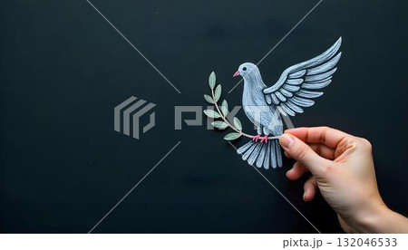 A hand sketches a dove holding an olive branch on a blackboard, representing peace and unity 132046533