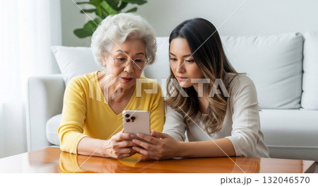 老人にスマホの操作方法を教える若い女性 132046570