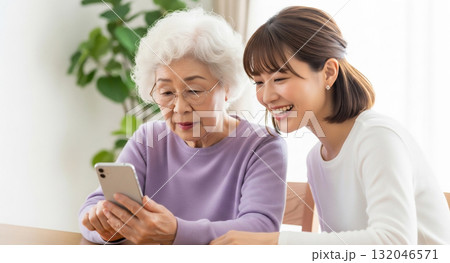 老人にスマホの操作方法を教える若い女性 老人にスマホの操作方法を教える若い女性 132046571