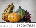 Autumn Harvest Display Of Pumpkins Gourds And Grapes On A Rustic Wooden Surface 132047689