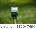 Green Handheld Moisture Meter in Outdoor Garden Setting for Soil Testing 132047690