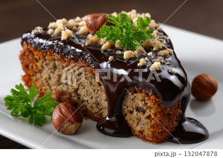 Delicious hazelnut cake slice topped with chocolate ganache Delicious hazelnut cake slice topped with chocolate ganache 132047878
