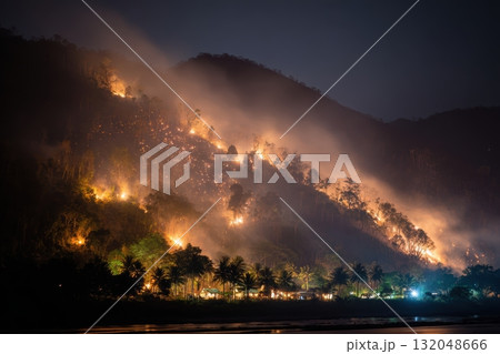 Forest fire spreads across hills under night sky Forest fire spreads across hills under night sky 132048666