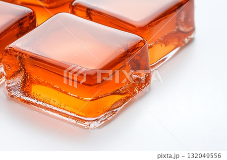 Transparent orange gelatin cubes on a white background with glossy reflections Transparent orange gelatin cubes on a white background with glossy reflections 132049556