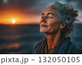 夕陽に包まれて深呼吸する中年女性 132050105