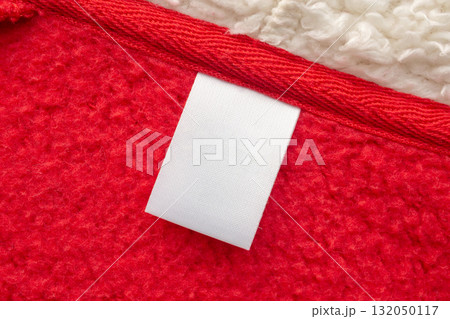 Blank white laundry care clothes label on red shirt fabric texture background Blank white laundry care clothes label on red shirt fabric texture background 132050117
