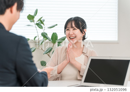 商談中にセールスマンの話を聞いて笑顔になる女性客 132051096