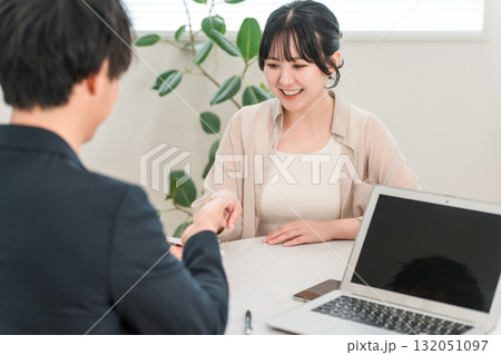 商談で電卓を使い金額を提示するビジネスマンと話を聞く女性客 商談で電卓を使い金額を提示するビジネスマンと話を聞く女性客 132051097