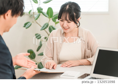 商談で電卓を使い金額を提示するビジネスマンと話を聞く女性客 商談で電卓を使い金額を提示するビジネスマンと話を聞く女性客 132051098