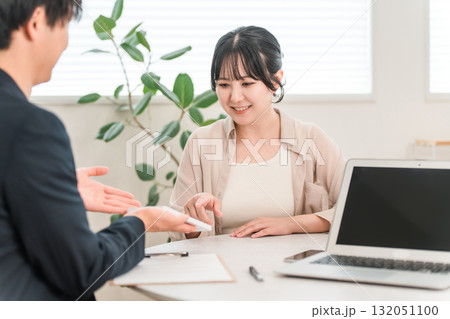 商談で電卓を使い金額を提示するビジネスマンと話を聞く女性客 商談で電卓を使い金額を提示するビジネスマンと話を聞く女性客 132051100