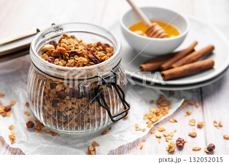 Homemade honey granola in jar with cinnamon sticks Homemade honey granola in jar with cinnamon sticks 132052015