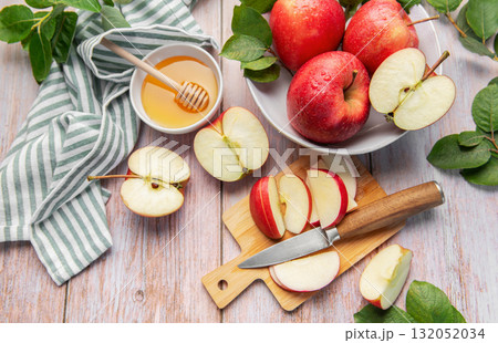 Sliced red apples and honey on wooden table Sliced red apples and honey on wooden table 132052034