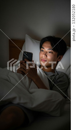 ベッドに寝転がりスマホを操作する女性 132052180