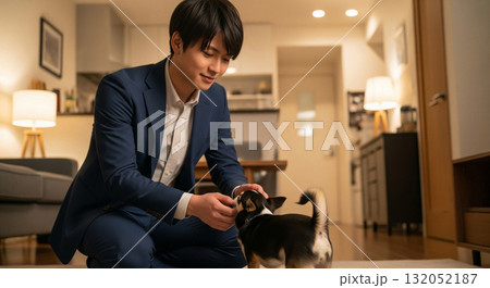愛犬が尻尾を振って駆け寄る。 笑顔でしゃがみ込み優しく撫でる 愛犬が尻尾を振って駆け寄る。 笑顔でしゃがみ込み優しく撫でる 132052187