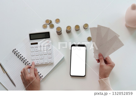 Financial management. A person reviewing bills and calculating expenses with a calculator. 132052859
