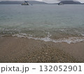 フィッツロイ島–貝殻混じりの砂浜と遠くに浮かぶ小舟 132052901
