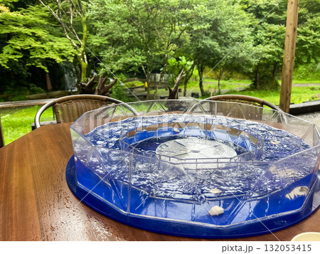 流しそうめん。そうめんを水に入れて回転させる機械。日本の夏の風物詩。 流しそうめん。そうめんを水に入れて回転させる機械。日本の夏の風物詩。 132053415