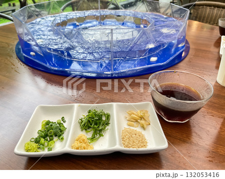 流しそうめん。そうめんを食べるためのツユと薬味。日本の夏の風物詩。 流しそうめん。そうめんを食べるためのツユと薬味。日本の夏の風物詩。 132053416